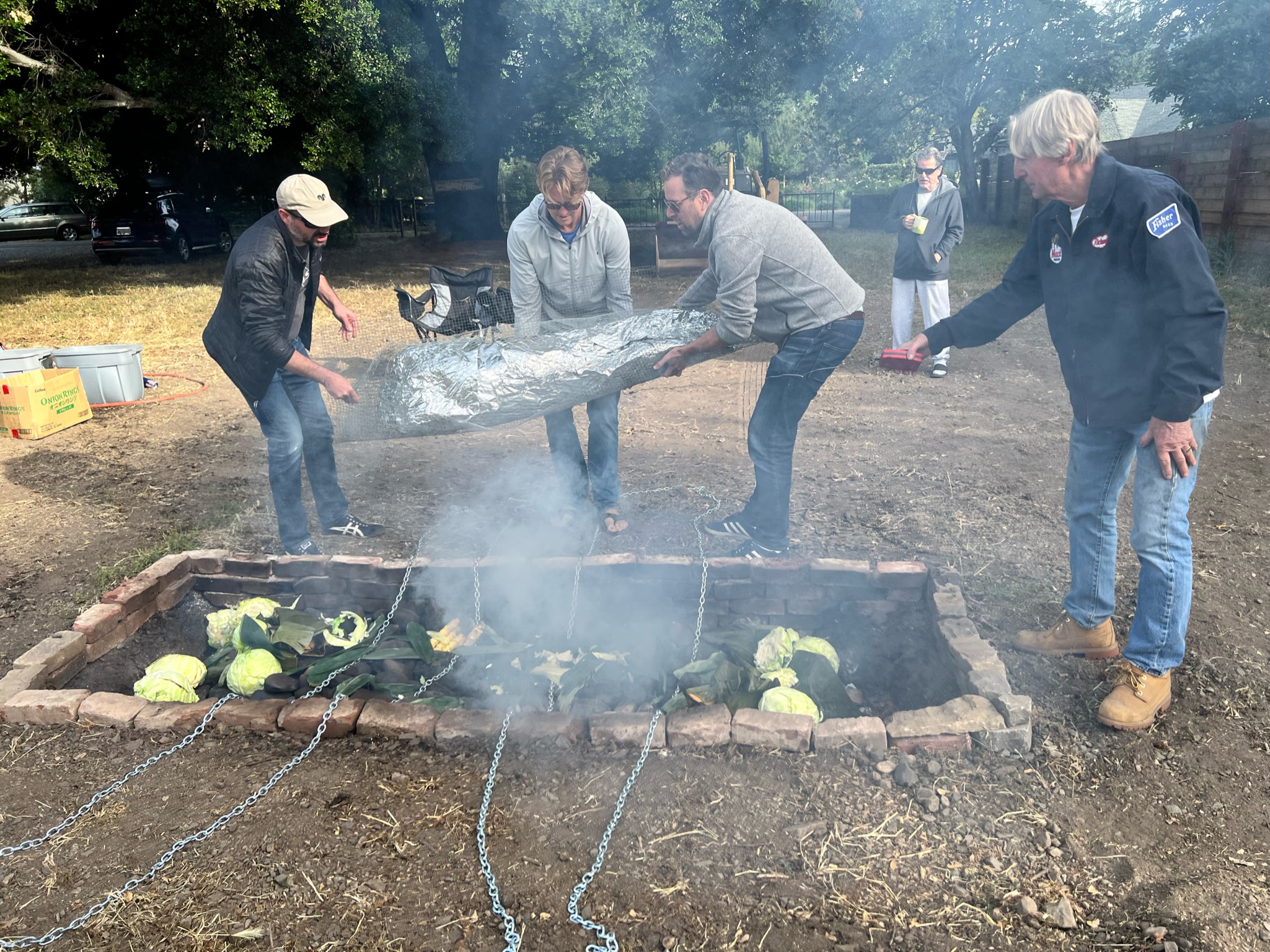 Lifting the pig into the Imu. We&rsquo;re holding a flat layer of denser chicken wire that we put underneath to make it a little easier to carry.